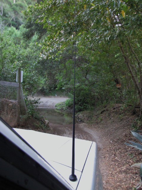 1992 Ford Explorer - Driving through a water crossing on a dirt path in a wooded area.