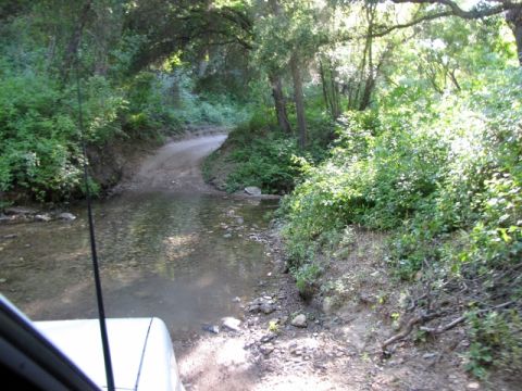 1992 Ford Explorer - Driving through a stream on a wooded dirt road.