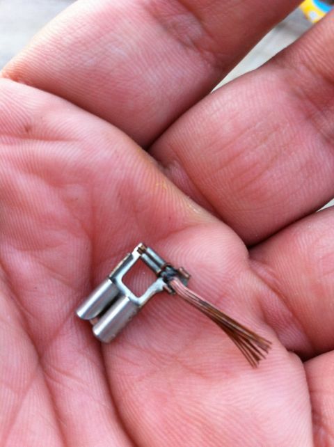1995 Ford Mustang - A close-up of a brake light switch connector with exposed wires, held in a person's hand.