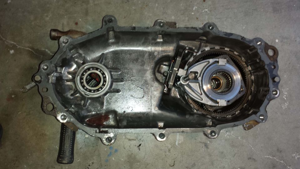 Open metal transfer case with bearing and gears visible
