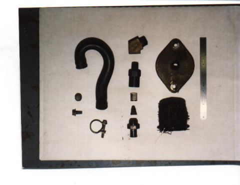 1965 Ford 427 - Various automotive parts are displayed on a flat surface next to a metal ruler.