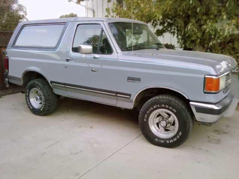1994 Ford Bronco - Light blue 1994 Ford Bronco with aftermarket wheels and tires.