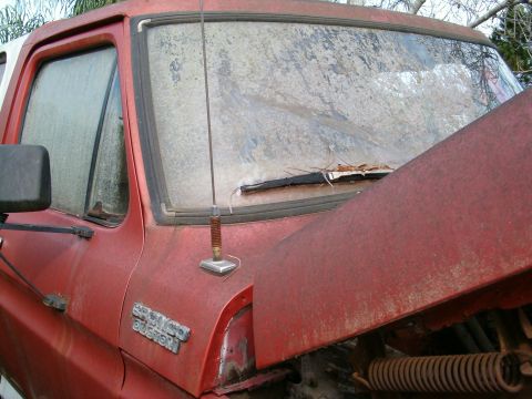 1979 Ford Bronco - A red pickup truck with a dirty windshield and a "BRONCO CUSTOM" badge is shown from 1978.