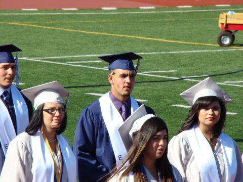 1989 Ford Bronco - Students in graduation attire are gathered on a sports field.