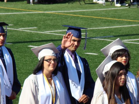 1989 Ford Bronco - Graduates in caps and gowns stand on a football field during a ceremony.