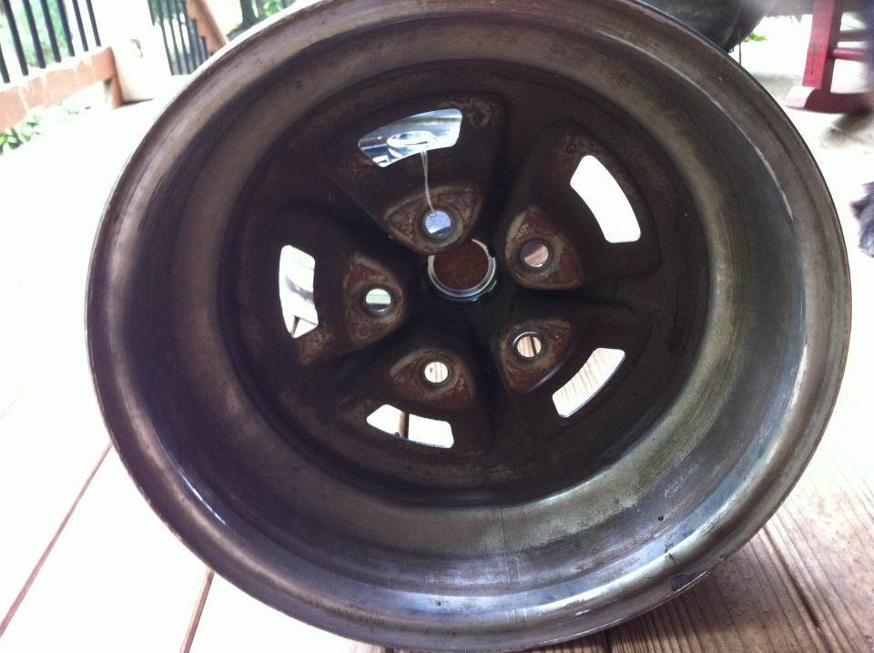 Close-up of a five-spoke vehicle wheel with a rusty finish