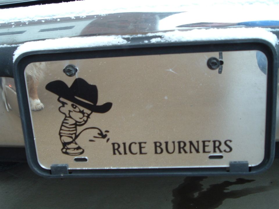 Chrome bumper license plate reading RICE BURNERS with a peeing cowboy decal