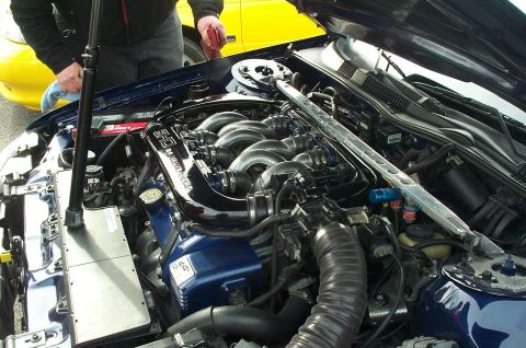 2001 Ford Taurus - Close-up of a modified engine bay, with a yellow car partially visible behind it.