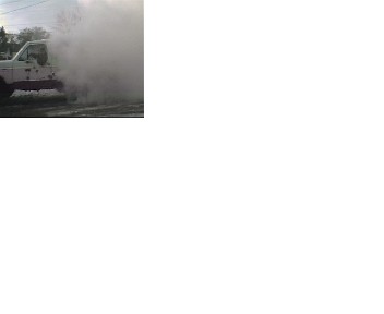 1980 Ford Bronco - A white pickup truck creates a large spray of water as it drives.