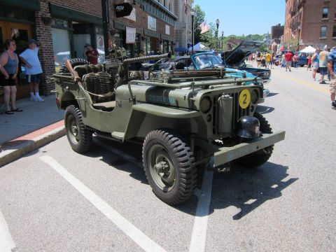 1991 Ford LTD Crown Victoria - Rear view of an olive drab military jeep marked with a white star and yellow circle parked at a street car show.