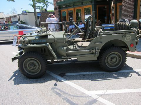 1991 Ford LTD Crown Victoria - Side view of an olive drab military jeep with a mounted machine gun and hood serial 2035806 at a car show.