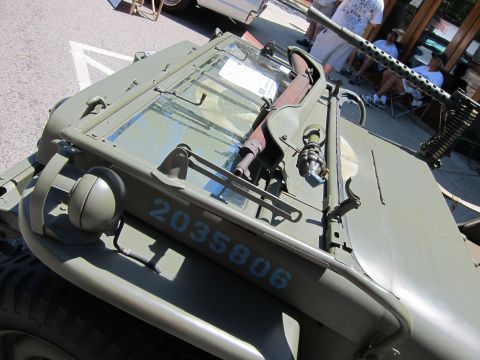 1991 Ford LTD Crown Victoria - Close-up of an olive drab military vehicle's cowl and folded windshield showing white serial number 2035806.