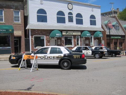 1991 Ford LTD Crown Victoria - row of vintage police cars including a Marlborough cruiser and Highway Patrol sedans parked along a downtown street.