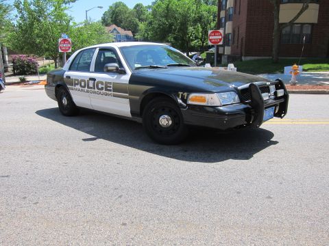 1991 Ford LTD Crown Victoria - Front three-quarter view of a black-and-white Marlborough police car with a push bar, parked on a residential street.