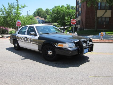 1991 Ford LTD Crown Victoria - Front three-quarter view of black-and-white Marlborough police car unit T1 with a push bar, parked near a Do Not Enter sign.