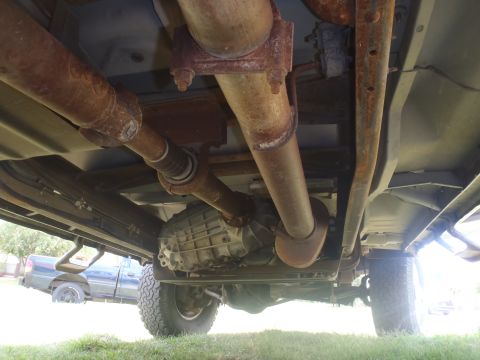 1997 Ford F-350 - The underside of a truck's drivetrain is visible, with another truck in the background.