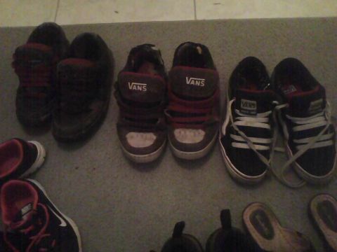2003 Ford Crown Victoria - A collection of Vans sneakers, including red and black high-tops and low-tops, are displayed on the floor.