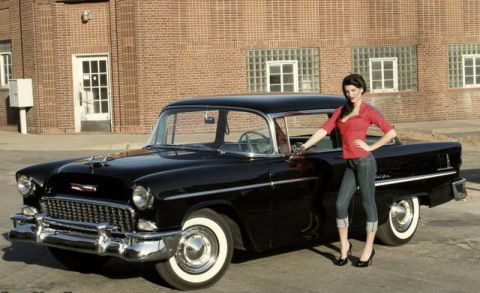 1991 Ford LTD Crown Victoria - A classic black 1955 Chevrolet Bel Air is shown with a woman posing next to it.