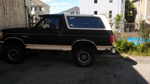 1993 Ford Bronco - Side view of a two-tone Ford Bronco, possibly a 1992 model, with a visible "SUPERMOTORS" watermark.