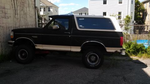 1993 Ford Bronco - This 1993 Ford Bronco is parked in an alleyway with buildings in the background.