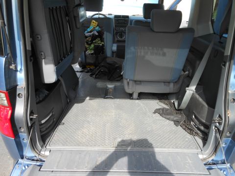 1996 Ford F-150 - The spacious interior of a blue van features folded rear seats and durable diamond plate flooring.