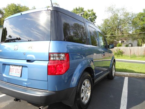 1996 Ford F-150 - A blue Honda Element is parked in a lot, viewed from the rear quarter angle.