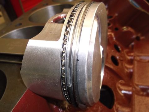 1970 Ford Mustang - Close-up of an engine piston with rings, positioned within a cylinder block.