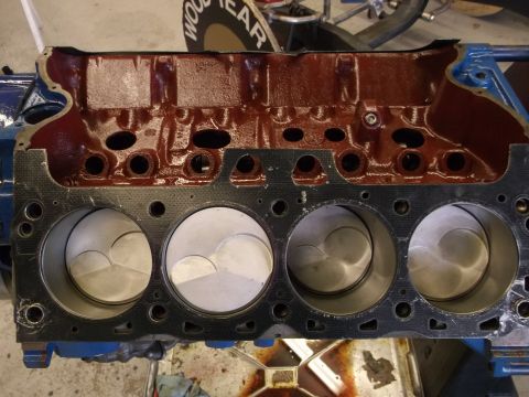 1970 Ford Mustang - Close-up of an engine block with pistons installed, revealing the internal structure and cylinder walls.