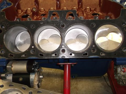 1970 Ford Mustang - Close-up view of an engine block's cylinders and pistons, with a starter motor mounted below.