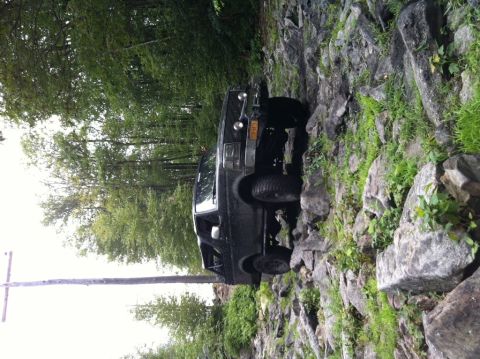1995 Ford Bronco - This SUV appears to be from the early to mid-1990s, likely a Ford Bronco, as it tackles a challenging off-road course.