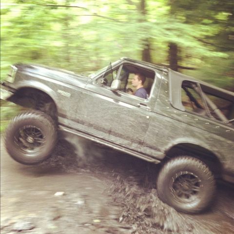 1995 Ford Bronco - This 1995 Ford Bronco navigates a muddy off-road course with a driver behind the wheel.