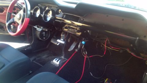 1987 Ford Bronco - The interior of a car shows exposed wiring and a floor shifter, suggesting a custom build or repair.