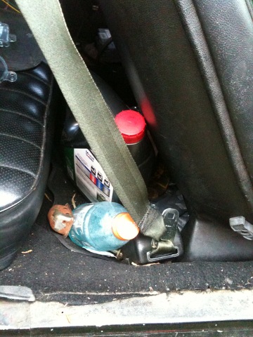 1975 Chevrolet Chevelle - A close-up view of the floor area behind a car seat, showing various items.
