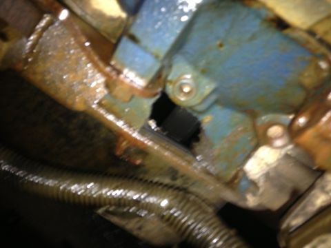 1995 Ford Bronco - Close-up view of a blue engine component with visible rust and a corrugated hose, likely part of a Cummins swap.