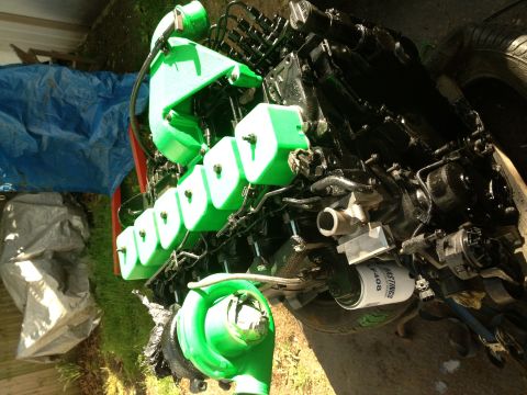 1995 Ford Bronco - A diesel engine, possibly a Cummins, is shown with a bright green intake manifold and turbocharger, sitting outdoors.