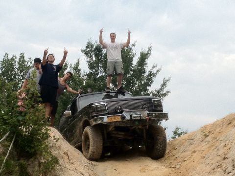 1995 Ford Bronco - A group of friends celebrate their off-road adventure atop a modified truck.