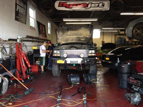1995 Ford Bronco - A 1995 Ford Bronco is being worked on in a garage, with its hood open and dyno equipment set up.