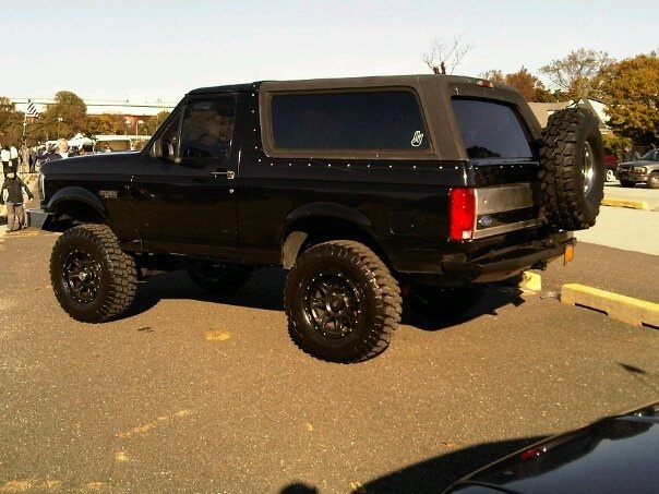 Black Ford Bronco, lifted with off-road tires, viewed from the rear three-quarter angle