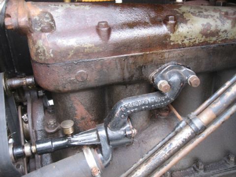 1912 Ford Model T - A close-up view of an engine component with visible rust and a "STANDARD MOTOR" label.