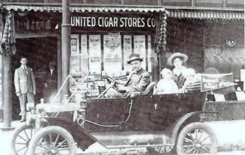 1912 Ford Model T - A family poses in their 1912 Ford Model T outside a United Cigar Stores Co. establishment.
