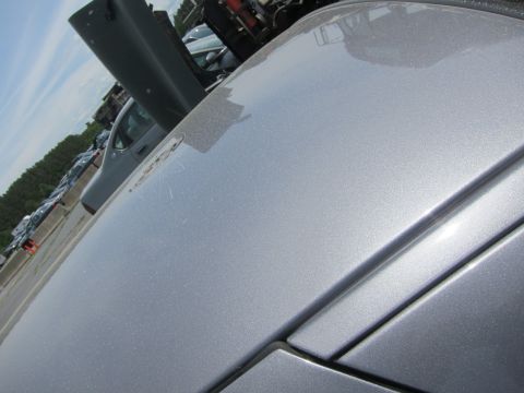 1991 Ford LTD Crown Victoria - Detail shot of a silver car's body panels with other vehicles in a lot.