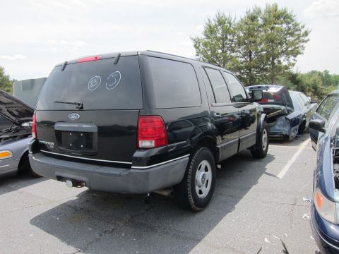 1991 Ford LTD Crown Victoria - Rear view of a black Ford Expedition SUV, parked outdoors with other vehicles nearby.