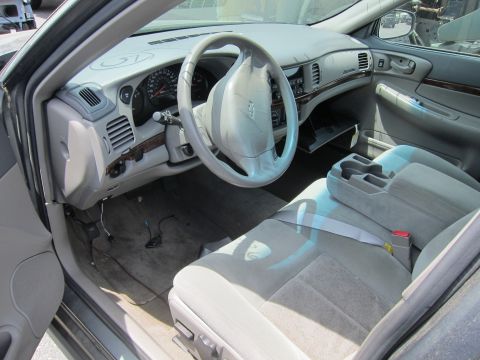 1991 Ford LTD Crown Victoria - Interior view of a car with light grey upholstery and a visible steering wheel and dashboard.