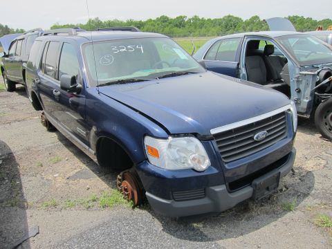 1991 Ford LTD Crown Victoria - Junkyard Ford Explorer SUV missing wheels, with handwritten number 3254 on windshield.