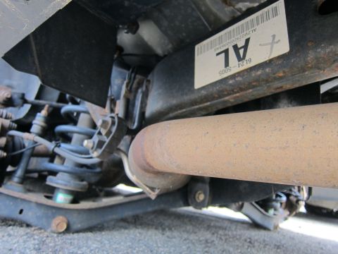 1991 Ford LTD Crown Victoria - Vehicle's rear suspension and exhaust system detail, with a part number visible on a label.