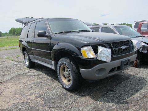 1991 Ford LTD Crown Victoria - A black Ford Explorer from the early 2000s sits in a lot with other vehicles.
