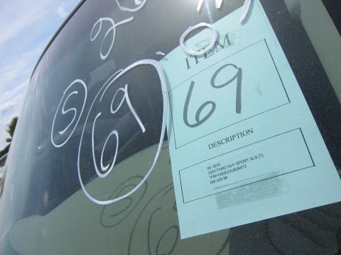 1991 Ford LTD Crown Victoria - Auction lot description tag for a 2003 Ford SUV taped inside a window, not a technical document.
