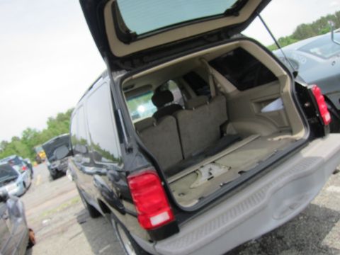 1991 Ford LTD Crown Victoria - Rear view of an open-top SUV parked outdoors with other vehicles around.