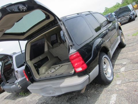 1991 Ford LTD Crown Victoria - Rear view of a black SUV with its hatch open, revealing the cargo area. Other vehicles are visible in the background.