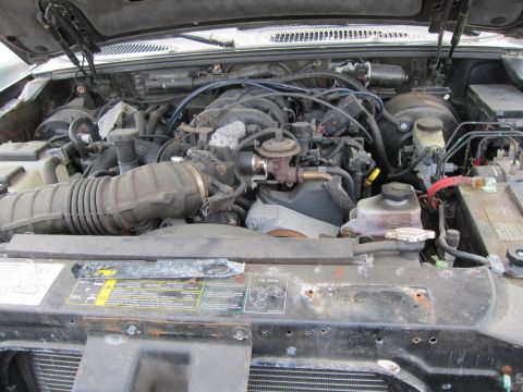 1991 Ford LTD Crown Victoria - The engine bay of a vehicle is shown with the hood open, revealing the engine and surrounding components.